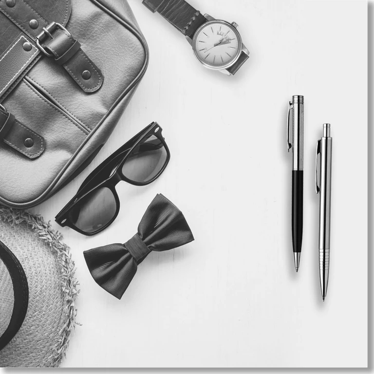Metal pens next to a watch, sunglasses and other accessories